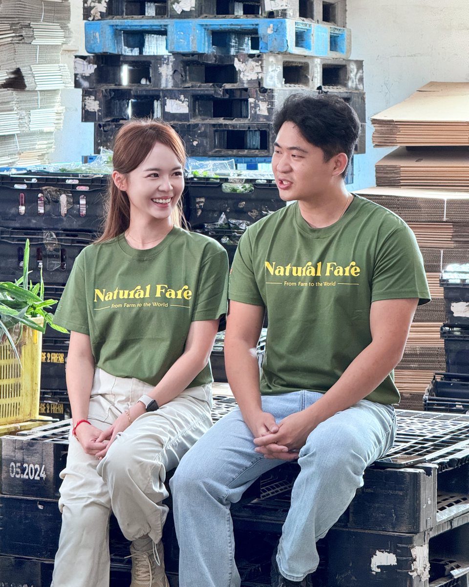 Chia Wai Xiang and Lee Ching Lou in green Natural Fare T-shirts, seated together and smiling